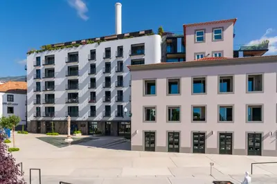 a large white building next to a street at Savoy Insular II by An Island Apart in Funchal