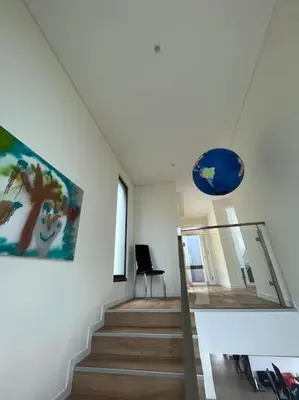 a staircase in a house with a painting on the wall at Villa Arco Iris in Arco da Calheta