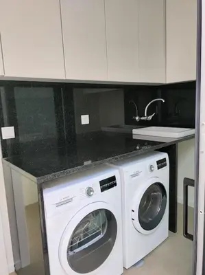 a kitchen with a washer and dryer under a counter at Villa Arco Iris in Arco da Calheta