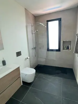 a bathroom with a shower and a toilet and a sink at Villa Arco Iris in Arco da Calheta