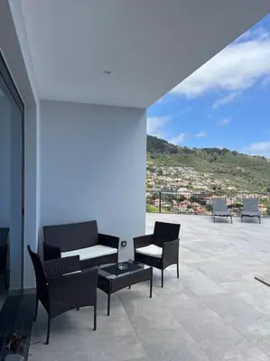 a patio with chairs and a table on a building at Villa Arco Iris in Arco da Calheta