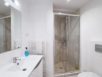 a white bathroom with a shower and a sink at Beach Retreat Steps from the Ocean #1953 in Luz