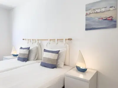 a bedroom with two beds with blue and white pillows at Beach Retreat Steps from the Ocean #1953 in Luz