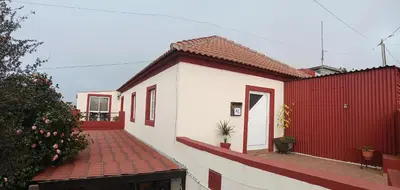 a red and white house with a red fence at Achadas da Cruz Farm House in Achadas da Cruz