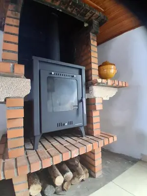a tv sitting on top of a brick fireplace at Achadas da Cruz Farm House in Achadas da Cruz