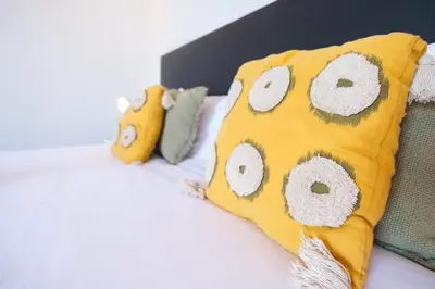 a bed with a yellow pillow with owls on it at GuestReady - Aragão Guest house in Funchal
