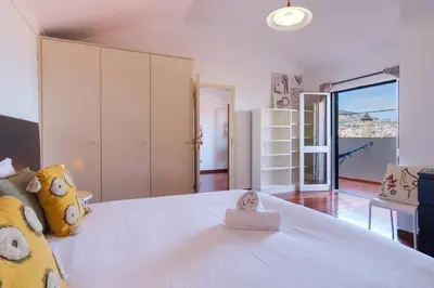 a bedroom with a large white bed with a toy on it at GuestReady - Aragão Guest house in Funchal