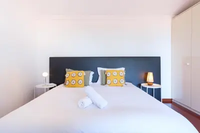 a bedroom with a large white bed with yellow pillows at GuestReady - Aragão Guest house in Funchal