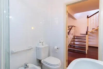 a bathroom with a toilet and a staircase at GuestReady - Aragão Guest house in Funchal