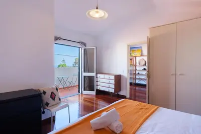 a bedroom with a bed and a view of a balcony at GuestReady - Aragão Guest house in Funchal