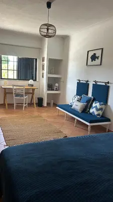 a living room with a blue couch and a table at Eco Natura Falcoeira - Praia da Luz in Montinhos da Luz