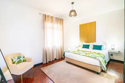 a bedroom with a bed and a chair at Lighthouse view- POOL VILLA in Porto Moniz