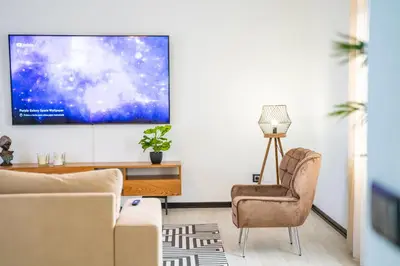a living room with a couch and a tv on a wall at Lighthouse view- POOL VILLA in Porto Moniz