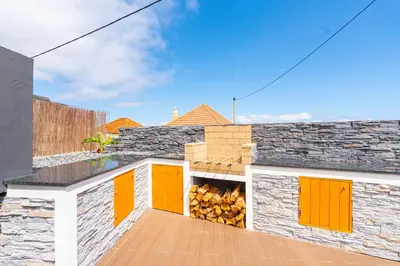 a deck with a fire pit on top of a house at Lighthouse view- POOL VILLA in Porto Moniz