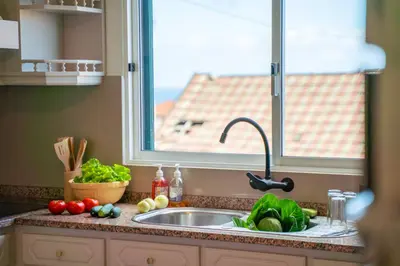 a kitchen counter with a sink and a window at Lighthouse view- POOL VILLA in Porto Moniz