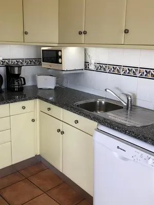 a kitchen with a sink and a microwave at Bel appartement 2 pieces, bord de mer et vue mer in Lagos