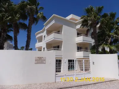 a white building with palm trees in front of it at Bel appartement 2 pieces, bord de mer et vue mer in Lagos