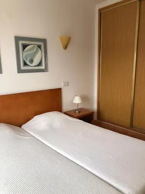 a bedroom with a bed and a cabinet and a lamp at Bel appartement 2 pieces, bord de mer et vue mer in Lagos