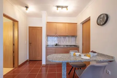 a kitchen with a table and a clock on the wall at Moniz Centro I in Porto Moniz