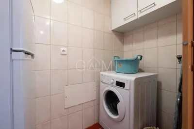 a washing machine with a bucket on top of it in a bathroom at Moniz Centro I in Porto Moniz