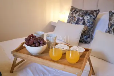 a tray with a bowl of fruit and glasses of orange juice at Moniz Centro I in Porto Moniz