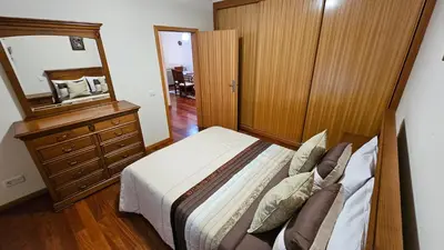 a bedroom with a bed and a dresser and a mirror at Garajau Paradise Apartment in Caniço