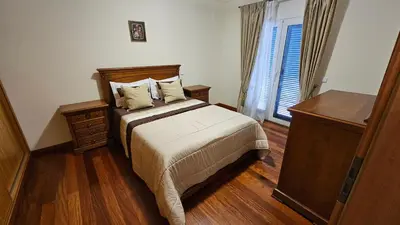 a bedroom with a bed and a dresser and a window at Garajau Paradise Apartment in Caniço