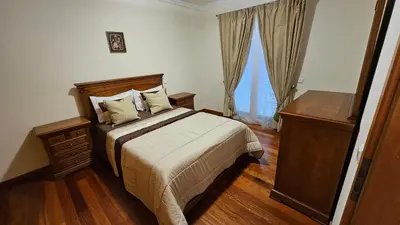 a bedroom with a bed and a dresser and a window at Garajau Paradise Apartment in Caniço