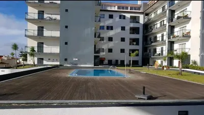 an empty swimming pool in front of a building at Garajau Paradise Apartment in Caniço
