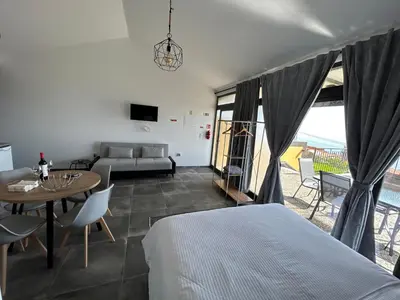 a bedroom with a bed and a table and a couch at Quinta Das Rosas 5 in Estreito da Calheta