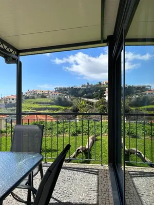 a patio with a table and chairs looking at a horse at Quinta Das Rosas 5 in Estreito da Calheta