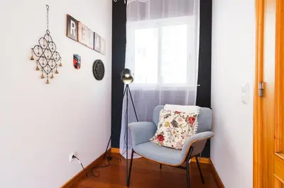 a room with a chair and a lamp and a window at GuestReady - TiClara Villa & Studio in Caniço