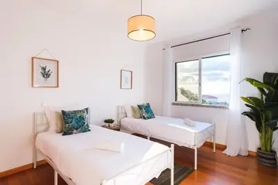 a white room with two beds and a window at GuestReady - TiClara Villa & Studio in Caniço