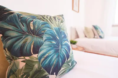 a couch with blue leaves on it in a living room at GuestReady - TiClara Villa & Studio in Caniço