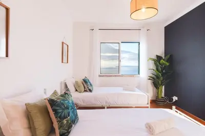 a living room with a couch and a window at GuestReady - TiClara Villa & Studio in Caniço
