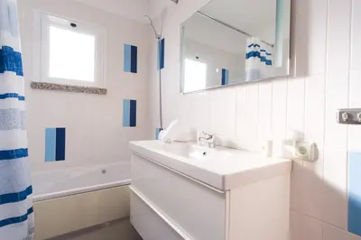 a white bathroom with a sink and a mirror at GuestReady - TiClara Villa & Studio in Caniço
