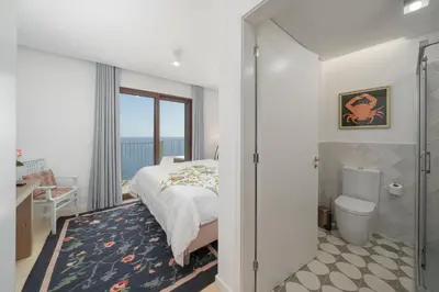 a bedroom with a bed and a bathroom at Islander - Funchal Seaside Villas in Funchal