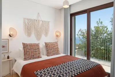 a bedroom with a bed and a large window at Islander - Funchal Seaside Villas in Funchal