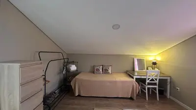 a small bedroom with a bed and a desk at Casa Malee in Calheta