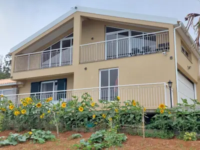 a house with a balcony and sunflowers at Casa Malee in Calheta