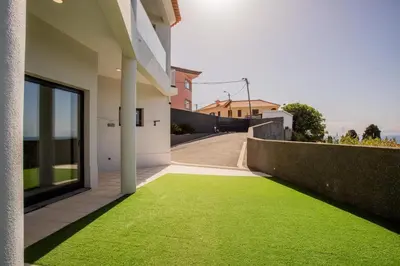 a yard of green grass next to a building at Pena View Villa in Santa Cruz