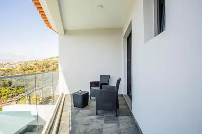 a room with two chairs and a balcony with a view at Pena View Villa in Santa Cruz