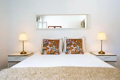 a bedroom with a white bed with two lamps at Enjoy the city center at fully equipped 2 BR 5 Min walk to beach & market in Funchal