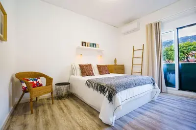 a white bedroom with a bed and a window at Enjoy the city center at fully equipped 2 BR 5 Min walk to beach & market in Funchal