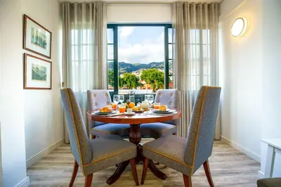 a dining room with a table and chairs and a window at Enjoy the city center at fully equipped 2 BR 5 Min walk to beach & market in Funchal
