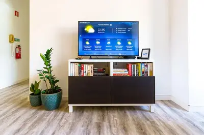 a television sitting on a tv stand in a living room at Enjoy the city center at fully equipped 2 BR 5 Min walk to beach & market in Funchal
