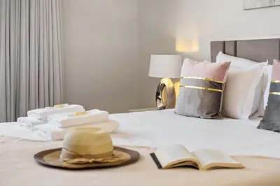 a hotel room with a bed with a hat and books at Glimpse of the City by Homie in Funchal