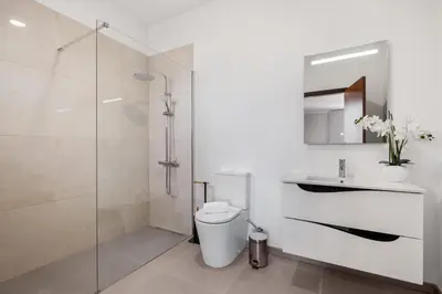 a bathroom with a shower and a toilet and a sink at Glimpse of the City by Homie in Funchal