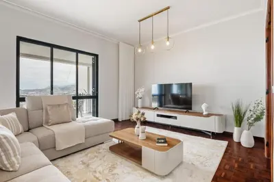 a living room with a couch and a tv at Glimpse of the City by Homie in Funchal