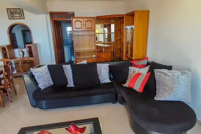 a living room with a black couch with pillows at The funny and Relax apartment with terrace & view in Arco da Calheta
